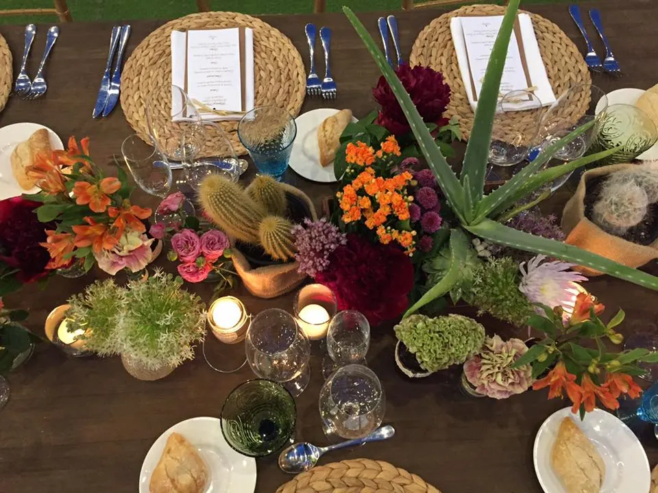 Mesa de boda decorada con flores, cactus y velas